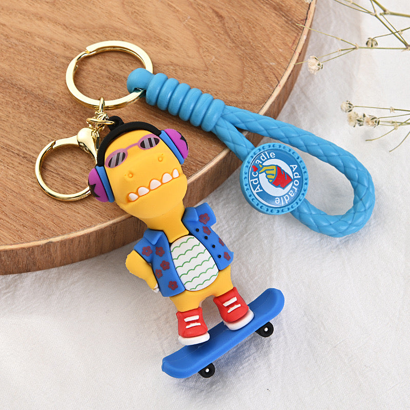 🦖 Cute Dinosaur Keychain – Music & Skateboard Edition